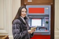 Woman hand showing dollar banknotes in front of the atm Royalty Free Stock Photo