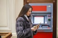 Woman hand showing dollar banknotes in front of the atm Royalty Free Stock Photo