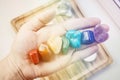 Woman hand sowing all seven color chakra crystal stones. Royalty Free Stock Photo