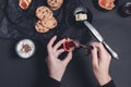 Woman hand with spoon jam and biscuits near cup of coffee or cappuccino chocolate cookies on black table background. Afternoon b Royalty Free Stock Photo