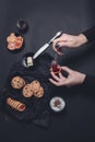 Woman hand with spoon jam and biscuits near cup of coffee or cappuccino chocolate cookies on black table background. Afternoon b Royalty Free Stock Photo