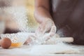 Woman hand sprinkling white flour on dough Royalty Free Stock Photo