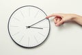 Woman hand stop time on a round clock, time management and deadline concept Royalty Free Stock Photo