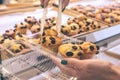 Woman hand with sweet cake with raisins in the bakery, Bali island, Indonesia.