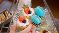 Woman hand take a dessert tart from sweet traditional Afternoon tea stand