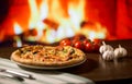 Woman hand take slice of Pizza over fireplace background with tomatoes Royalty Free Stock Photo