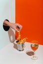 woman hand takes fried shrimp in metal bucket through paper hole modern hard shadow glass of wine