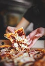 Woman Hand takes a slice of chicken Pizza in paper box Royalty Free Stock Photo