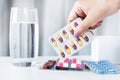 woman hand taking antibiotics pill with a glass of water on a table Royalty Free Stock Photo