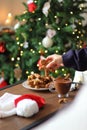Woman hand taking christmas gingerbread cookie from plate and hot chocolate. Royalty Free Stock Photo