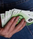 Woman hand taking money from jeans back pocket. Woman hiding money behind her back. EURO banknotes close up