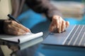 Woman hand taking notes on notebook using laptop in the night Royalty Free Stock Photo