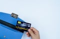 Woman hand taking out the credit card from blue purse for payment on the white background. Finance and money concept, top view, Royalty Free Stock Photo