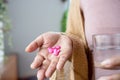 Woman hand taking painkiller pink ibuprofen pills , handful of overdose medicines Royalty Free Stock Photo