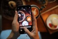 Woman Hand Taking Photo Food by Mobile Phone in coffee shop Royalty Free Stock Photo