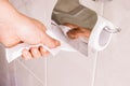 Woman hand taking toilet paper from a toilet paper roll Royalty Free Stock Photo