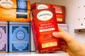 Woman hand taking Twinings tea box out of cupboard shelf