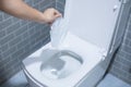 Woman hand throw paper towels in the toilet bowl. Cleaning, Lifestyle and personal hygiene concept Royalty Free Stock Photo