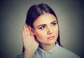 Woman with hand to ear gesture listening carefully