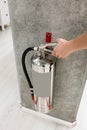 Woman hand touching and checking the chrome fire extinguisher Royalty Free Stock Photo