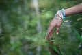 Woman hand touching water with boho style rings and bracelets en