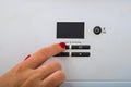 Woman hand try to turn off and on the central heating in the room. Female hands on the central heating control panel. Girl hand Royalty Free Stock Photo