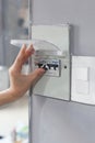 Woman hand turning off fuse box in the house. Royalty Free Stock Photo