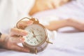 Woman hand turns off alarm clock waking up in morning