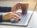 Woman hand type on Laptop Keyboard with Coffee cup Royalty Free Stock Photo