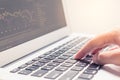 Woman hand typing on laptop keyboard with graph on screen Royalty Free Stock Photo