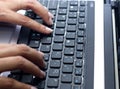 Woman hand typing laptop's keyboard