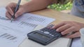 A woman hand uses a calculator and calculates about the cost at home. Financial management concept