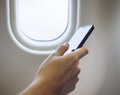 Woman Hand using cell phone in Airplane Royalty Free Stock Photo