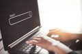 Woman hand using keyboard laptop with search bar icon on screen at coffee shop. Business technology and freelance concept Royalty Free Stock Photo