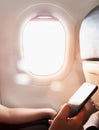 Woman hand using smart phone on the airplane Royalty Free Stock Photo