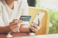 Woman hand using smart phones and holding credit card for shopping payment online, or for business, finance, and payment concepts Royalty Free Stock Photo
