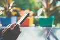 Woman hand using smartphone with cafe shop sunlight shade to object beautiful background. Royalty Free Stock Photo