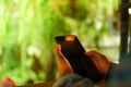 Woman hand using smartphone with cafe shop sunlight shade to object beautiful background. Royalty Free Stock Photo