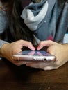 Woman hand using smartphone at cafeteria. Young female using smart phone at restaurant Royalty Free Stock Photo