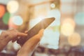 Woman hand using smartphone and laptop with cafe shop colorful beautiful bokeh background Royalty Free Stock Photo