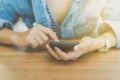 Woman hand using smartphone with cafe shop sunlight shade to object beautiful background. Royalty Free Stock Photo