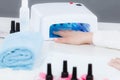 Woman hand in uv led lamp drying gel manicure