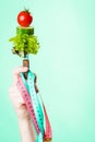 Woman hand with vegetarian food and measuring tapes. Royalty Free Stock Photo