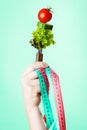 Woman hand with vegetarian food and measuring tapes. Royalty Free Stock Photo