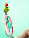 Woman hand with vegetarian food and measuring tapes.