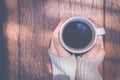 Woman hand in warm sweater holding a cup of coffee on a wooden t Royalty Free Stock Photo