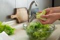 Woman hand washing lettuce in kitchen