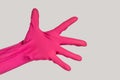 Woman hand wearing pink rubber glove showing her open palm give me something. Royalty Free Stock Photo