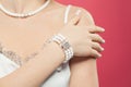 Woman hand wearing silver jewelry bracelet with pearls on pink background Royalty Free Stock Photo