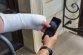 Woman hand in white plaster cast holds mobile phone Royalty Free Stock Photo
